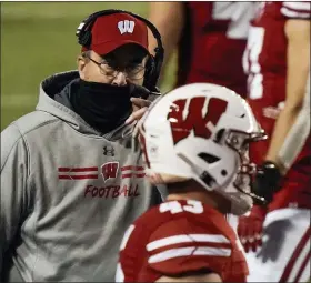  ?? MORRY GASH — THE ASSOCIATED PRESS ?? Wisconsin coach Paul Chryst talks to players during Friday’s win over Illinois. The Badgers’ game at Nebraska Saturday has been cancelled due to the number of those associated with the program testing positive for coronaviru­s, including Chryst.
