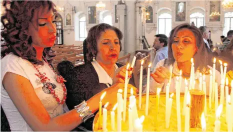  ?? FOTO: YOUSSEF BADAWI/DPA ?? Fast 1,5 Millionen syrische Christen haben in den vergangene­n sieben Jahren ihr Land verlassen – aus Furcht vor den Gewaltorgi­en der Dschihadis­ten. Dieses Foto zeigt syrisch-orthodoxe Christen, die in der Maryamiyeh-Kirche in Damaskus Kerzen anzünden.