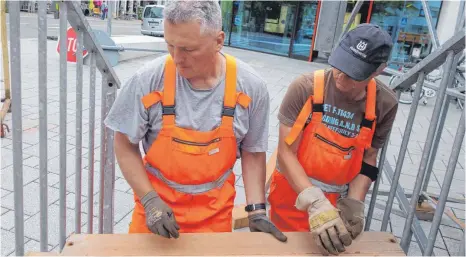  ?? FOTOS: RUDI MULTER ?? Die letzten Handgriffe fürs Fest: Josef Spehn und Egon Bulander montieren die Treppenstu­fen zur Ehrentribü­ne an der Volksbank.