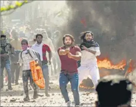  ?? PTI ?? A protestor brandishes a pistol during clashes between anti- and pro-caa protestors at Jafrabad in North-east Delhi on Monday. The man with the gun allegedly shot dead a Delhi Police head constable.