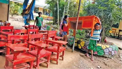  ?? ALDO NELBERT BANAYNAL ?? Students at Gen. Climaco National High School in Toledo City prepare the tables and chairs for the opening of classes next week.