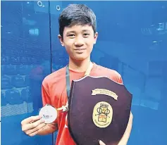  ??  ?? Harith Danial Jefri with the trophy and medal after winning the Boys U13 singles title.