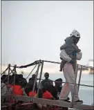  ??  ?? Un bébé secouru en mer est pris en charge par un humanitair­e espagnol.