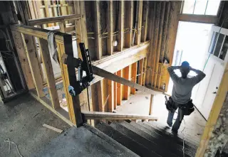  ??  ?? Eli Jacobo works inside a house on Glenview Drive. It is among the last to be rebuilt, more than seven years after the blast, a reminder of how long it takes to recover from a disaster.