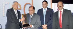  ??  ?? Prime Minister Ranil Wickremesi­nghe presents the award to Commercial Bank Chairman Dharma Dheerasing­he in the presence of the bank’s Deputy Chairman Preethi Jayawarden­a (extreme right) and ICCSL Chairman Dinesh Weerakkody