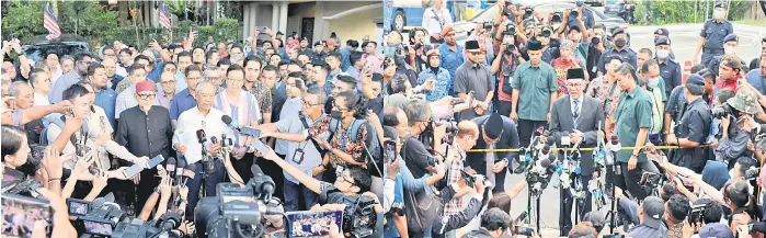  ?? — Bernama photos ?? Muhyiddin addresses the press at his residence in Kuala Lumpur following his audience with the King, as (right) Anwar does the same at Gate 2 of Istana Negara.