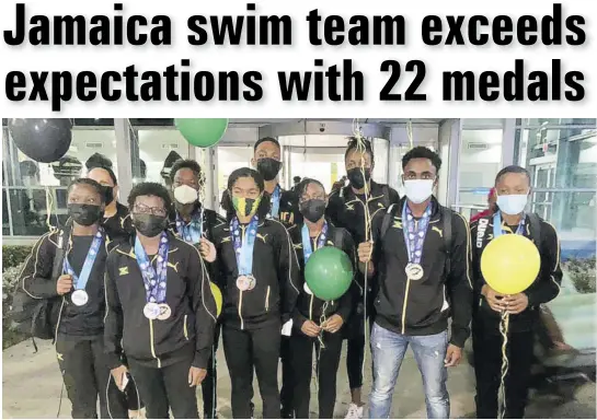  ??  ?? Members of the successful swim team share a photo opportunit­y shortly after arriving at the Norman Manley Internatio­nal Airport on Monday.