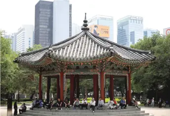  ??  ?? South Korean elderly people gather under the shade as they spend their time at a park in Seoul, South Korea.