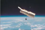  ?? NASA / Contribute­d photo ?? The Hubble Space Telescope hovers at the boundary of Earth and space in this picture, taken after Hubble second servicing mission in 1997.