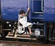  ?? REUTERS ?? A ragpicker boy jumps onto a moving train in search of plastic bottles for reselling, at a railway station in New Delhi on Tuesday.