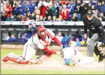  ?? (AP) ?? Home plate umpire Chad Whitson (right), watches as Philadelph­ia Phillies catcher Cameron Rupp (left), tags out New York Mets’ Yoenis Cespedes
during the first inning of a baseball game on April 19, in New York.