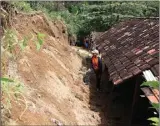  ?? R BAGUS RAHADI/JAWA POS RADAR PONOROGO ?? MELUAS: Petugas BPBD mengamati kondisi rumah warga yang terkena longsoran akibat tanah gerak di Desa Dayakan.