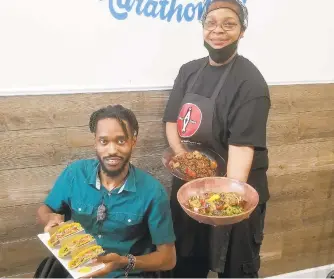  ?? PHOTOS BY RYAN KNELLER/THE MORNING CALL ?? Almost Vegan, a pescataria­n cafe serving wild-caught seafood, plant-based dishes and organic smoothies, opened Saturday at 627 W. Liberty St. in Allentown. Co-owner Anthony Alexander (left) holds a plate of salmon tacos, while executive chef Katrena Polo holds a shrimp quinoa stir-fry and a teriyaki grilled shrimp kabob salad.