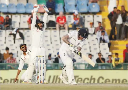  ??  ?? MOHALI: India’s Ajinkya Rahane, left, and Parthiv Patel, center, make a successful appeal against England’s Ben Stokes, right, on the third day of their third cricket test match in Mohali, India, yesterday. —AP