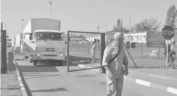  ?? AGENCE FRANCE PRESSE ?? Lorries part of a Russian humanitari­an aid convoy wait to cross the border at the Donetsk-Izvarino border checkpoint, near the town of Donetsk in the Rostov region.