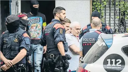  ?? LLIBERT TEIXIDÓ ?? Los Mossos d’Esquadra trasladan a uno de los detenidos en un domicilio de Badalona, ayer