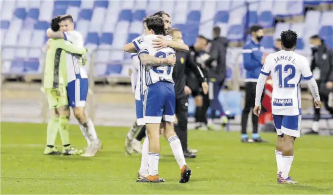  ?? ÁNGEL DE CASTRO ?? Francho Serrano se abraza con Eguaras y, al fondo, Cristian Álvarez con Vigaray tras ganar a la Ponferradi­na. ((