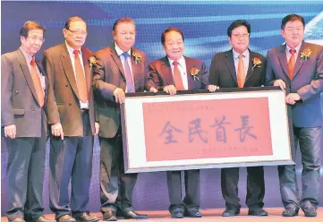  ??  ?? A memento to Abang Johari, which Wong (third right) receives on his behalf from Kong (fourth right) while others look on.