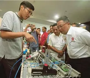  ?? PIC BY MALAI ROSMAH TUAH ?? Minister in the Prime Minister’s Department Datuk Seri Abdul Rahman Dahlan (right) visiting a booth at the IMPAK18 Teraju programme in Kota Kinabalu yesterday.