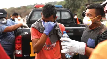  ??  ?? Bryan Rivera, who lost 13 members of his family during the eruption of the Fuego volcano, reacts while being comforted by vounteers after human after human remains were found at his home in San Miguel Los Lotes in Escuintla Guatemala. — Reuters photo