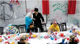  ?? (Mussa Qawasma) ?? A ‘ROYAL APOLOGY’ is engraved between curtains on the security wall, behind a mock tea party for Palestinia­n children in Bethlehem on Wednesday.