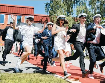  ?? JESSICA GOW/TT NEWS AGENCY ?? High school students run from a gymnasium June 3 after a graduation ceremony in Stockholm, Sweden.