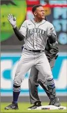  ?? David Berding / Getty Images ?? Julio Rodriguez of the Mariners celebrates his first career hit and double in the ninth inning against the Twins on Saturday.