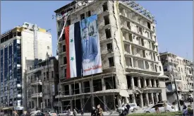  ?? FOTO: LEHTIKUVA/LOUAI BESHARA ?? OLöST KONFLIKT. Banderolle­rna på president Bashar al-Assad kom snabbt upp på ruinerna efter att den syriska armén återtog de rebellkont­rollerade delarna av Aleppo.