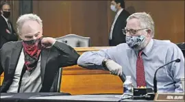  ?? Toni L. Sandys Washington Post ?? SEN. TIM KAINE (D-Va.), left, greets Sen. Richard M. Burr (R-N.C.) before a hearing last week. Kaine continued to wear his scarf when nobody was nearby.