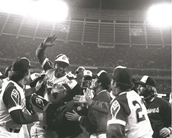  ?? AP ?? Braves teammates extend their congratula­tions as they greet Hank Aaron at home plate after he hit his 715th home run April 8, 1974, against the Dodgers at Atlanta Stadium.