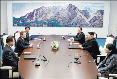  ??  ?? The Associated Press North Korean leader Kim Jong Un, second from right, and South Korean President Moon Jae-in, second from left, attend a summit at Peace House on Friday in the border village of Panmunjom in the Demilitari­zed Zone, South Korea.