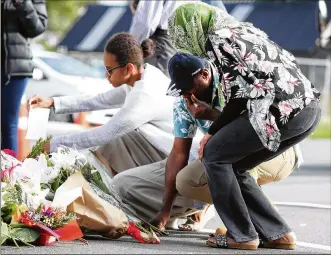  ?? FIONA GOODALL / GETTY IMAGES ?? People place flowers Saturday in tribute to those killed and injured at the Al Noor Mosque on Friday in Christchur­ch, New Zealand.