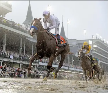  ?? AP/MORRY GASH ?? Mike1 Smith (center) rides Justify
to victory at the 144th Kentucky Derby on Saturday at Churchill Downs in Louisville, Ky. Justify won by 2 /2 lengths, becoming the first colt since Apollo in 1882 to win the Derby without racing as a 2-year-old.