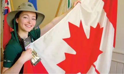 ??  ?? Chloe Ramm, étudiante à l’Université de Saint-Boniface et interprète pour le lieu historique national de Lower Fort Garry, tient le drapeau du Canada vêtue de l’uniforme de Parcs Canada.