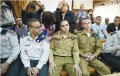  ?? (Amir Cohen/Reuters) ?? ACCUSED HEBRON SHOOTER Elor Azaria (center, seated) attends a remand hearing in Kiryat Malachi Military Court on March 31, as his father, Charlie, prays behind him.