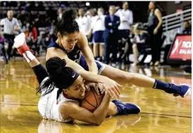  ?? MICHAEL WYKE / ASSOCIATED PRESS ?? Connecticu­t guard Crystal Dangerfiel­d (top) battles Houston guard Angela Harris for a loose ball. The top-ranked Huskies won 95-35 in advance of Monday’s showdown with No. 7 Texas in a game nationally televised on ESPN2.