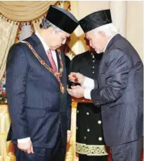  ??  ?? Abdul Taib conferring the Datuk Patinggi Bintang Kenyalang award on Ahmad Zahid at Astana Negeri in Kuching yesterday.