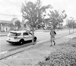  ?? PAUL BRINKMANN/STAFF ?? An Orange County deputy stops a tourist on Internatio­nal Drive, telling him to go back to his hotel. The county had set a mandatory curfew through 6 p.m. Monday.