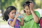  ?? Mel Melcon Los Angeles Times ?? LILLY SANTIAGO, 5, and her mother, Lupita, cool off at Lanark Recreation Center in Canoga Park. The region’s heat advisory is in effect until Saturday.