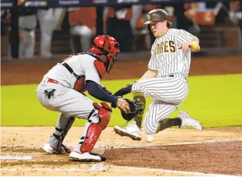  ?? K.C. ALFRED U-T ?? Padres’ Jake Cronenwort­h slides in and scores in the seventh inning as Yadier Molina can’t handle the throw.