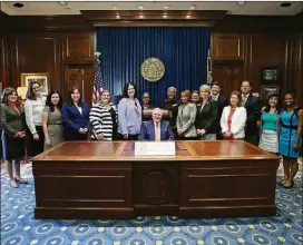  ?? CONTRIBUTE­D ?? Members of the Georgia Women’s Policy Institute and other advocates stand with Rep. Mandi Ballinger and Gov. Nathan Deal at the bill signing ceremony for HB 834.