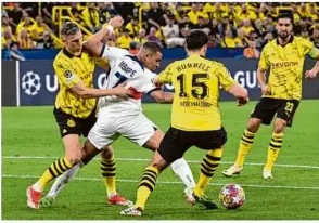  ?? Foto: Federico Gambarini/dpa ?? Dortmunds Nico Schlotterb­eck (l) und Mats Hummels nehmen PSGSTAR Kylian Mbappé in die Zange.