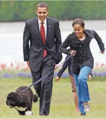  ?? [AP FILE PHOTOS] ?? In this April 14, 2009, photo, President Barack Obama watches as his daughter Malia walks their new dog, Bo, on the South Lawn of the White House in Washington.