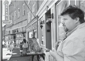  ?? AMY DAVIS/BALTIMORE SUN PHOTOS ?? G.E. Burgtorf of Ellicott City paints a staircase detail on Main Street on the block where the sidewalk caved in last July during a devastatin­g flash flood. Sunday was the final day of the Paint It! Elliott City “plein air” weekend event.