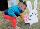  ??  ?? Zy’aire Gunn, 1, hunts for eggs on April 1 at Easter Land, a holiday-themed amusement park set up at People’s Church, 800 E Britton Road.