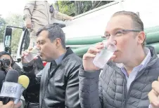  ??  ?? José Ramón Amieva, jefe de Gobierno local, y el edil de Benito Juárez, Santiago Taboada, bebieron un vaso de agua de una de las pipas sanitizada­s.