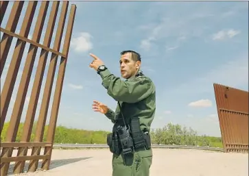  ?? Photograph­s by Carolyn Cole Los Angeles Times ?? BORDER PATROL Agent Robert Rodriguez discusses a series of gates that will be built to close gaps in the border wall near Peñitas, Texas. Residents will be able to open the gates using a pass code or remotely by radio.