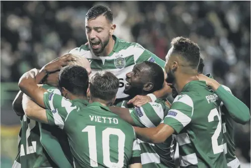  ?? PICTURE: FILIPE AMORIM/AFP VIA GETTY ?? 2 Sporting Lisbon players celebrate during a 4-0 Europa League group win over PSV last November, in which Bruno Fernandes, now of Manchester United, scored twice.