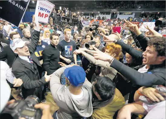  ?? Charles Rex Arbogast Associated Press ?? SUPPORTERS
of Donald Trump, left, face off with protesters after a rally at the University of Illinois campus in Chicago was canceled Friday over security concerns.