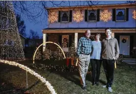  ?? TYLER SCHANK / DISPATCH ?? Scott and Tobey Huntley join their son, Ryan, in front of the Christmas lights display at their home in Upper Arlington. The family is accepting donations to the light show for Chris Collaros, principal of an Upper Arlington elementary school.